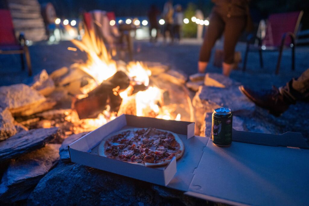 Sitting around fire with pizza